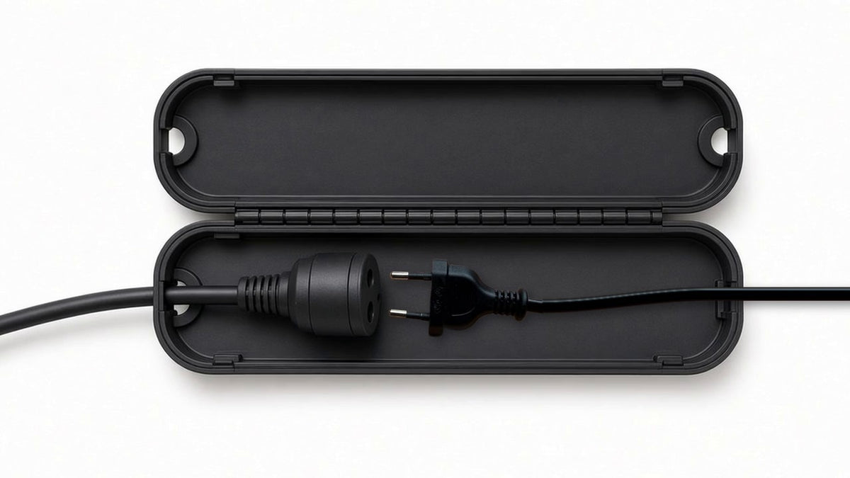 Geöffnete Kabel-Schutzbox mit dem Original-Netzstecker der Anlage und Verlängerungskabel