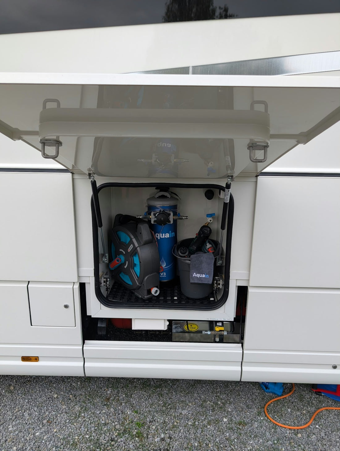 Aquain V3 mit Schlauchtrommel und Zubehör platzsparend im Staufach eines Wohnmobils verstaut.