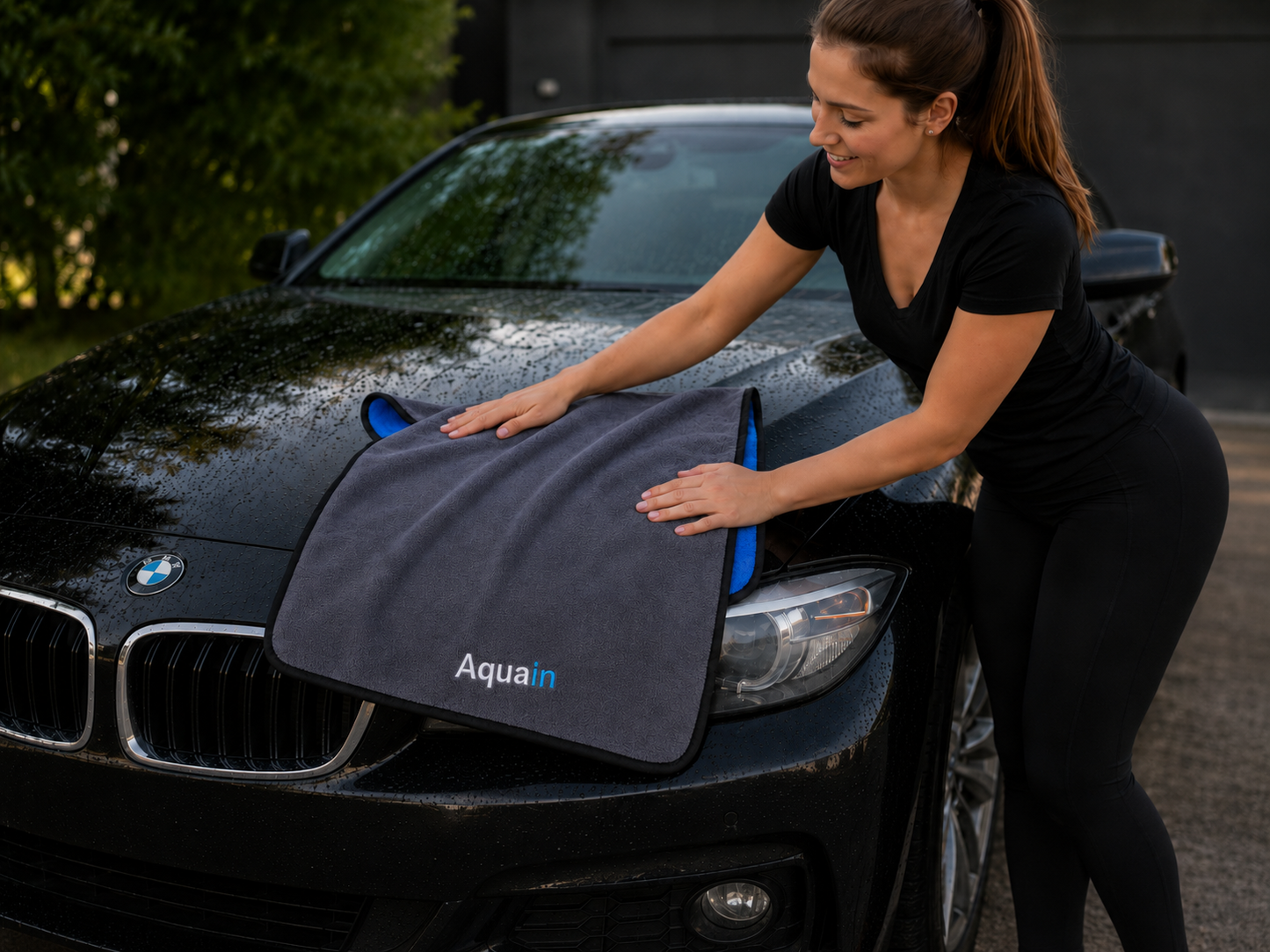 Frau trocknet eine nasse Motorhaube mit dem Aquain Auto-Trockentuch 60 × 90 cm und 800 GSM