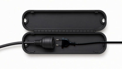 Geöffnete Kabel-Schutzbox mit dem Original-Netzstecker der Anlage und Verlängerungskabel